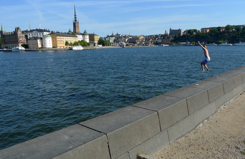 A young boy jumps into Lake Malaren near downtown Stockholm.